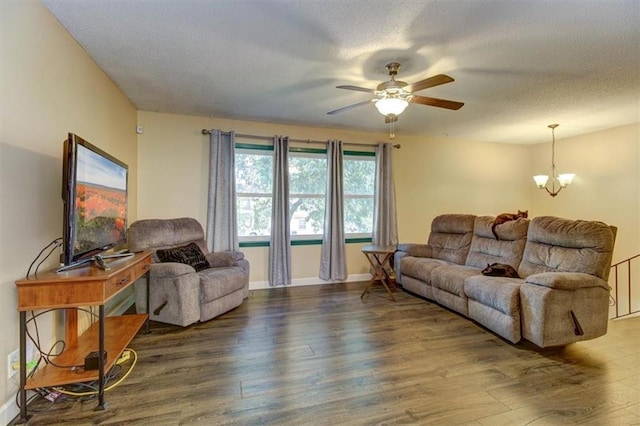 living room featuring hardwood / wood-style flooring, ceiling fan with notable chandelier, and a textured ceiling