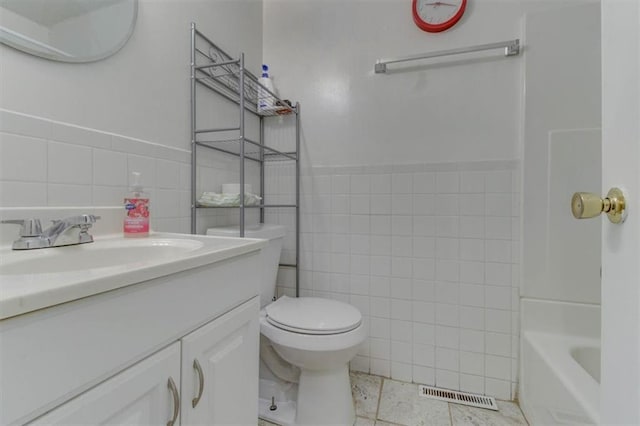 bathroom featuring vanity, tile walls, tile patterned floors, and toilet