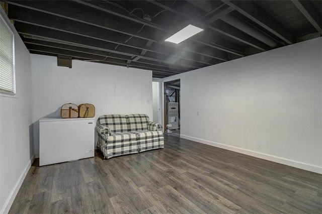 basement with gas water heater, fridge, and dark hardwood / wood-style floors