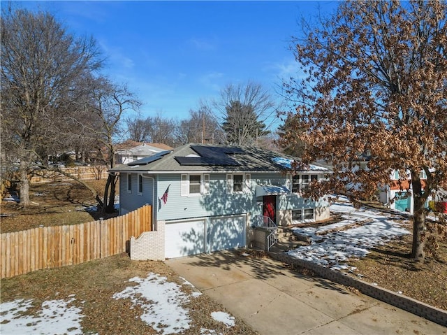 bungalow featuring a garage and solar panels