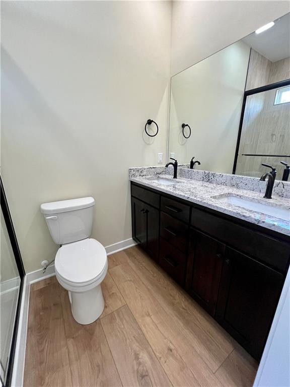 bathroom featuring vanity, an enclosed shower, hardwood / wood-style flooring, and toilet