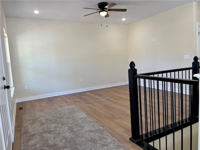 empty room featuring recessed lighting, baseboards, wood finished floors, and ceiling fan