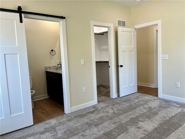 unfurnished bedroom with visible vents, carpet, and a spacious closet