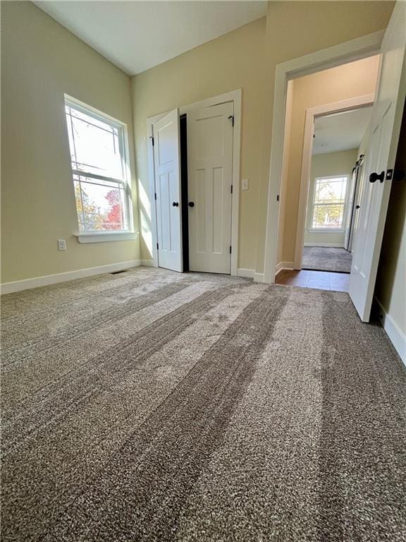 unfurnished bedroom featuring carpet and baseboards