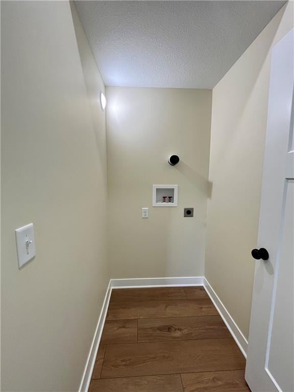 washroom featuring electric dryer hookup, a textured ceiling, dark wood finished floors, baseboards, and hookup for a washing machine