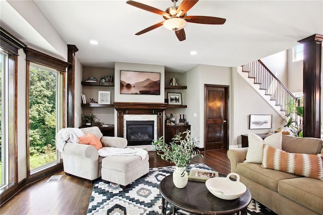 living room featuring ceiling fan and dark hardwood / wood-style floors