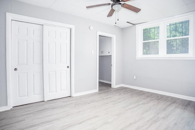 unfurnished bedroom featuring ceiling fan, a closet, wood finished floors, and baseboards