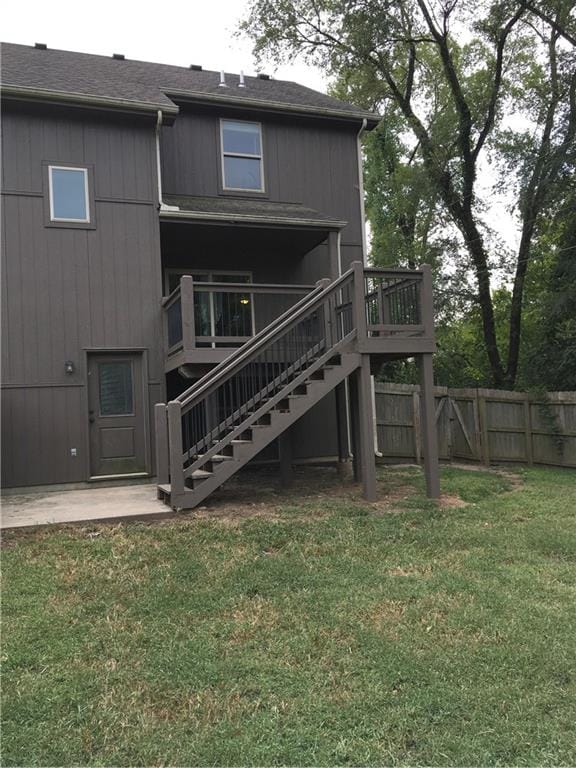 back of house featuring a lawn and a deck