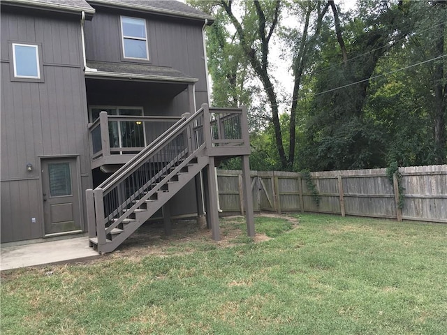 rear view of house featuring a deck and a lawn