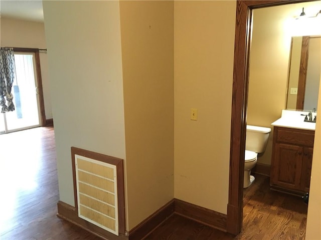 bathroom with vanity, toilet, and hardwood / wood-style flooring