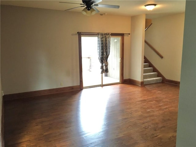 empty room with ceiling fan and dark hardwood / wood-style flooring