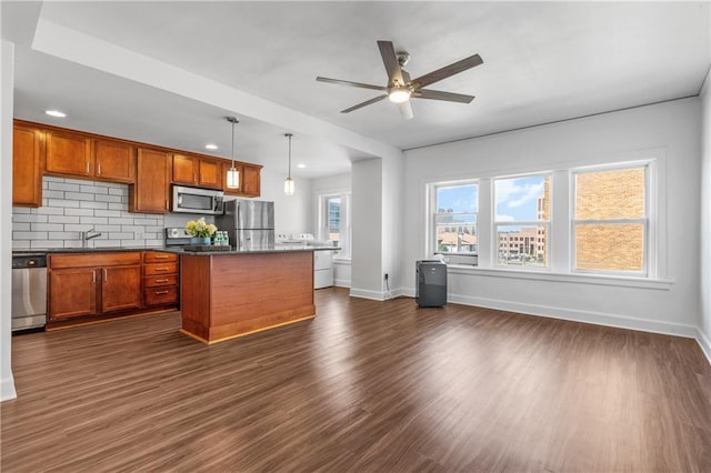 kitchen with tasteful backsplash, a kitchen island, ceiling fan, dark hardwood / wood-style floors, and appliances with stainless steel finishes