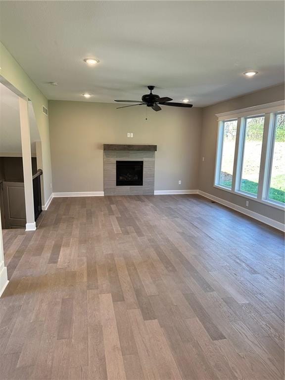 unfurnished living room featuring light wood-type flooring, a fireplace, and baseboards