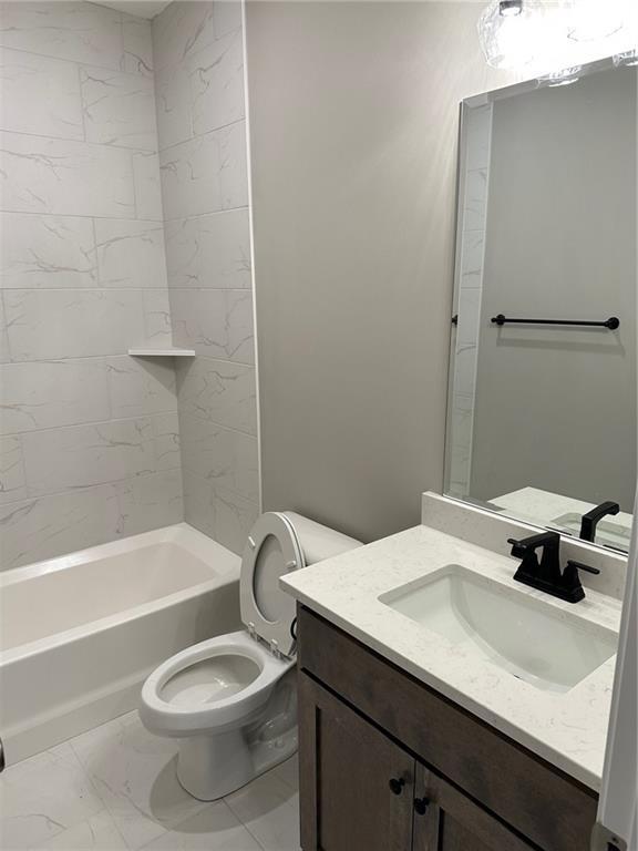 full bathroom featuring toilet, marble finish floor, shower / tub combination, and vanity