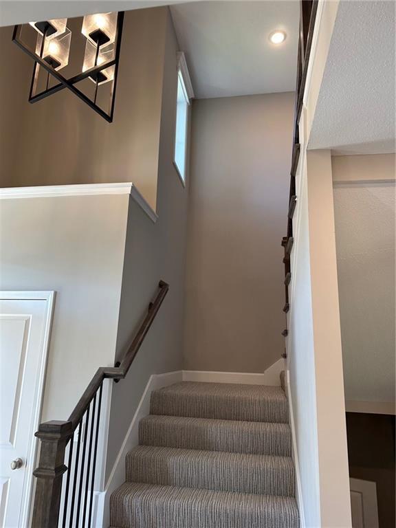 staircase with baseboards and recessed lighting