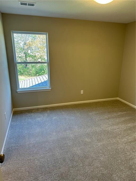 empty room featuring baseboards, a textured ceiling, visible vents, and carpet flooring