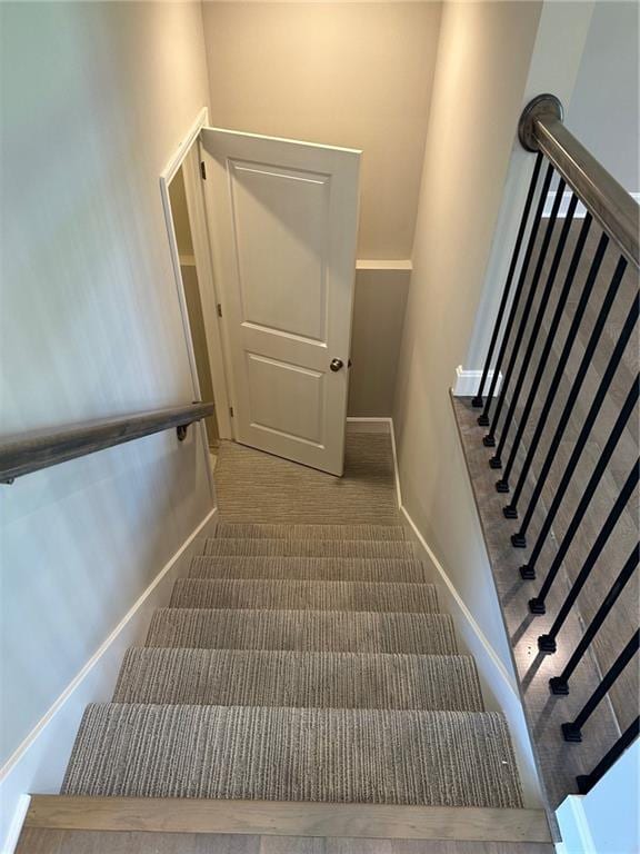 stairway featuring carpet floors and baseboards