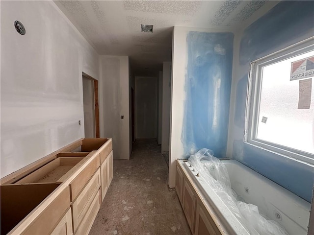 bathroom featuring a washtub, vanity, and a textured ceiling