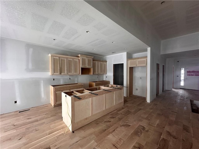 kitchen featuring light brown cabinets, light wood-type flooring, and a kitchen island