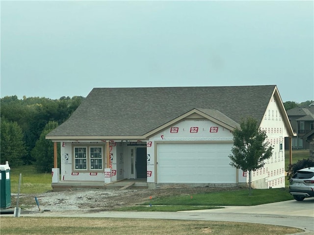 unfinished property featuring a garage and a front lawn