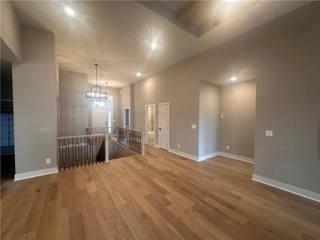 spare room with hardwood / wood-style flooring and a chandelier