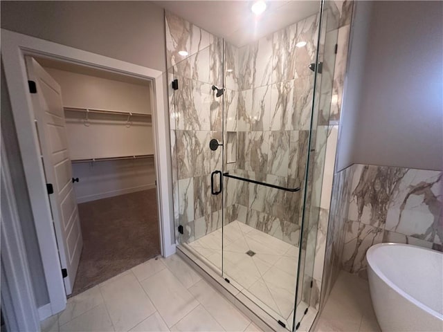 bathroom featuring tile walls and independent shower and bath