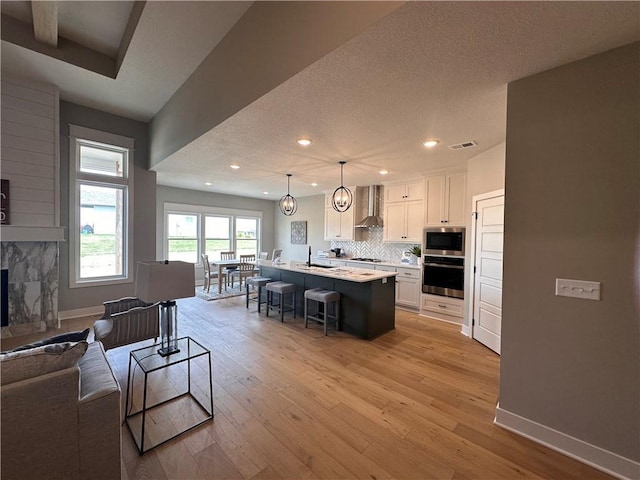 2007 Foxtail Pt, Kearney, MO 64060 - living room featuring light wood-style floors, recessed lighting, a textured ceiling, and a high end fireplace