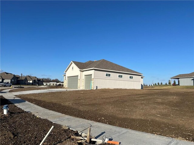 2007 Foxtail Pt, Kearney, MO 64060 - view of side of home with dirt driveway and an attached garage