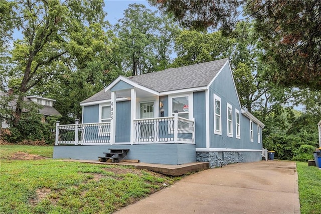 6825 Walrond Ave, Kansas City, MO 64132 - bungalow-style house featuring roof with shingles, covered porch, and a front lawn