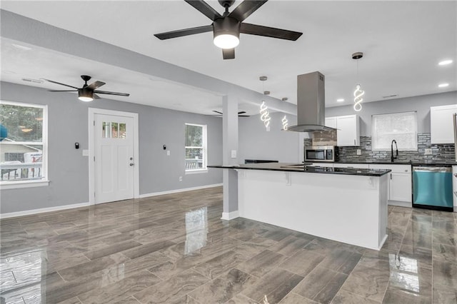 6825 Walrond Ave, Kansas City, MO 64132 - kitchen featuring island exhaust hood, dishwashing machine, a ceiling fan, stainless steel microwave, and dark countertops