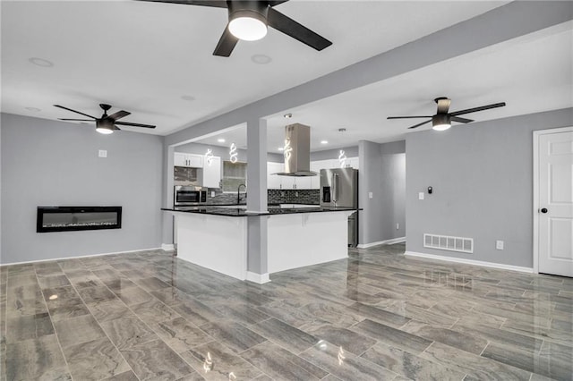 6825 Walrond Ave, Kansas City, MO 64132 - kitchen featuring island exhaust hood, a ceiling fan, and open floor plan