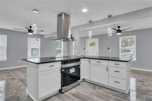 6825 Walrond Ave, Kansas City, MO 64132 - kitchen featuring ceiling fan, island range hood, stainless steel range with electric cooktop, open floor plan, and dark countertops