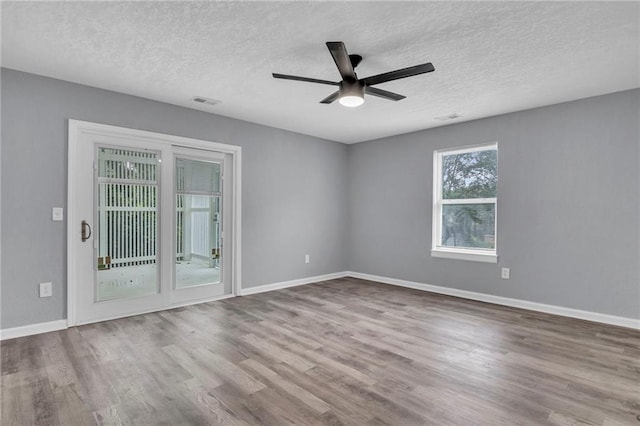 empty room with hardwood / wood-style floors, ceiling fan, and a textured ceiling