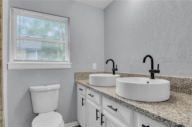 6825 Walrond Ave, Kansas City, MO 64132 - full bathroom featuring double vanity, a textured wall, and toilet