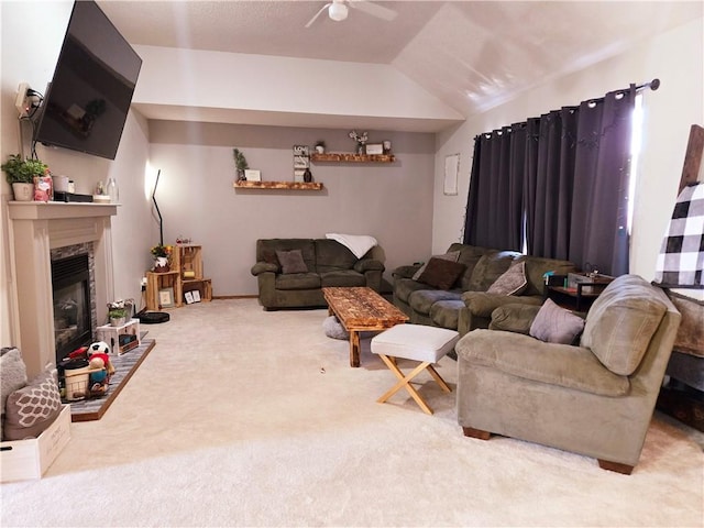 living room featuring ceiling fan, lofted ceiling, a fireplace, and carpet flooring