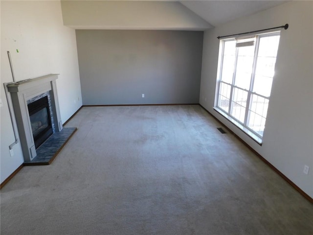 unfurnished living room featuring baseboards, a glass covered fireplace, carpet flooring, and vaulted ceiling