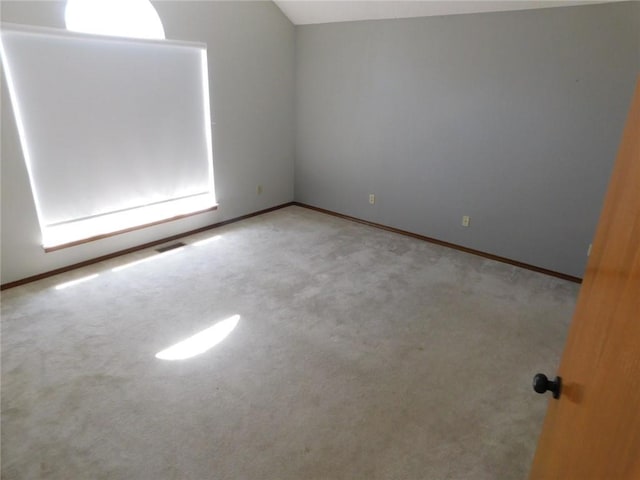 spare room with lofted ceiling and carpet flooring