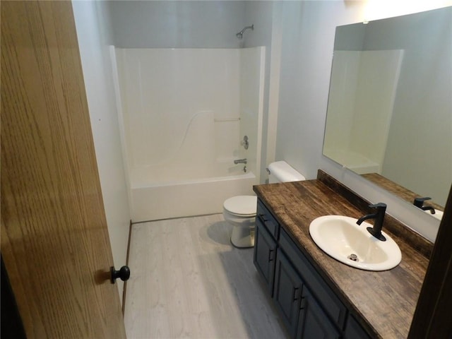 bathroom with shower / bathing tub combination, toilet, wood finished floors, and vanity