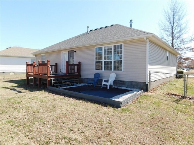 back of house with crawl space, a lawn, a deck, and a shingled roof