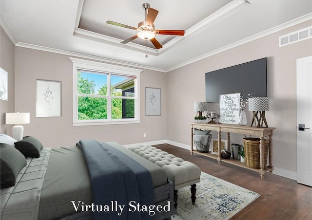 bedroom featuring ceiling fan, dark wood-type flooring, a raised ceiling, and ornamental molding