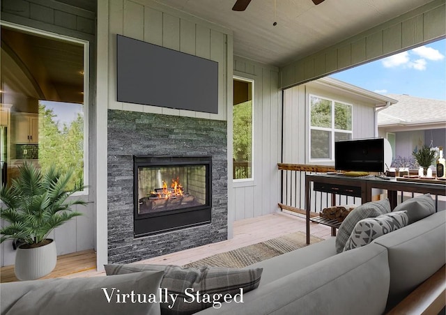 sunroom / solarium with ceiling fan and a fireplace