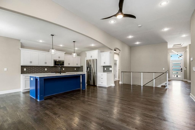 kitchen with white cabinetry, appliances with stainless steel finishes, dark wood-type flooring, and backsplash