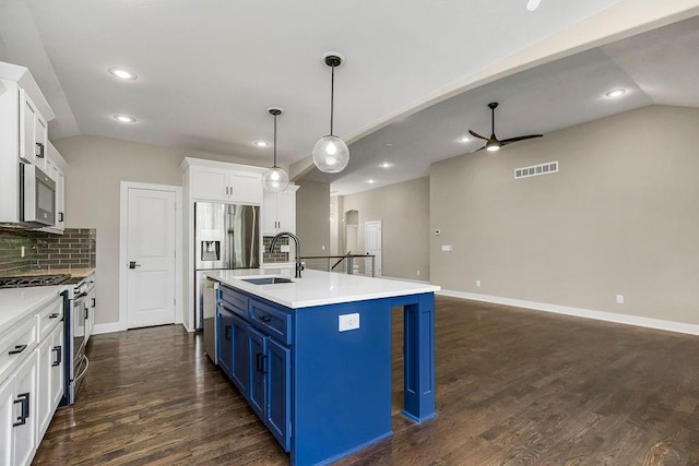 kitchen with sink, dark hardwood / wood-style flooring, decorative backsplash, stainless steel appliances, and a center island with sink