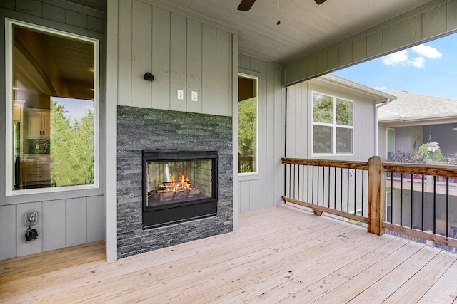 wooden terrace with a fireplace and ceiling fan