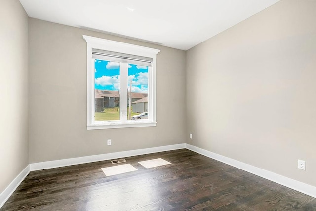 empty room with dark hardwood / wood-style flooring