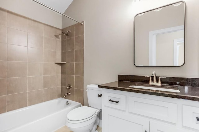 full bathroom featuring vanity, tiled shower / bath combo, and toilet