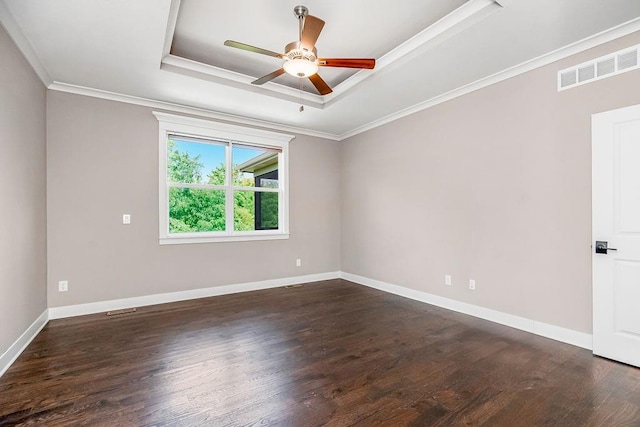 unfurnished room with ceiling fan, dark wood-type flooring, a raised ceiling, and crown molding