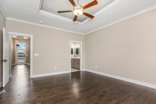 empty room featuring ceiling fan, crown molding, dark wood-type flooring, and a tray ceiling