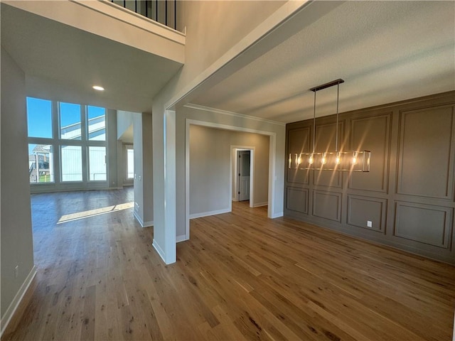 interior space featuring a chandelier, crown molding, hardwood / wood-style flooring, and a towering ceiling