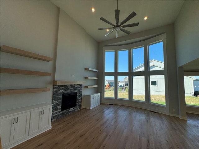 unfurnished living room with a fireplace, high vaulted ceiling, and plenty of natural light